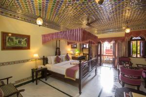 ein Schlafzimmer mit einem Bett in einem Zimmer mit einer Decke in der Unterkunft Umaid Bhawan - A Heritage Style Boutique Hotel in Jaipur