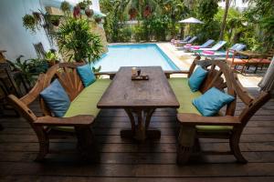 a wooden table and chairs next to a swimming pool at Greenlight Fisherman's Village Resort & Café in Koh Samui 