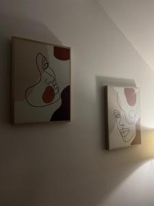 ニクシッチにあるApartman Niksicのランプの隣の壁に掛かっている2枚の絵 +1枚の写真