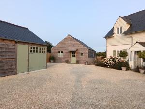 a driveway with two houses and a garage at Charming Countryside Chalet in Mégrit