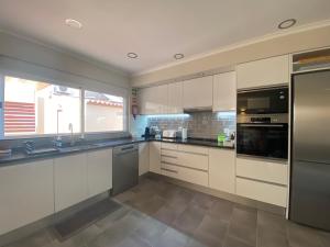 a kitchen with white cabinets and stainless steel appliances at Villa ELTAEL - Miguel House - Warm Pool until 1 November - Facilities for disabled guests in Manta Rota