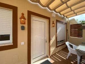a porch with a door and a table and chairs at Villa ELTAEL - Miguel House - Warm Pool until 1 November - Facilities for disabled guests in Manta Rota