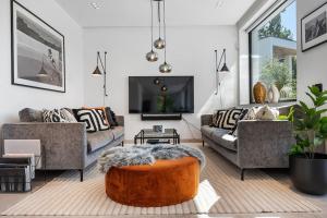 a living room with two couches and a tv at Lyxig villa i Solsidan in Stockholm