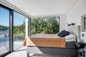 a bedroom with a bed and a large window at Lyxig villa i Solsidan in Stockholm +41 photos