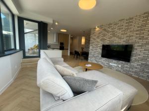 sala de estar con sofá blanco y pared de ladrillo en Rezidencia Galéria, en Ružomberok