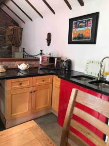 a kitchen with a black counter top and a sink at Stone Wall Cottage in Castlewellan