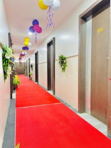 un couloir avec un tapis rouge et des ballons au plafond dans l'établissement Hotel rajlaxmi executive, à Aurangabad