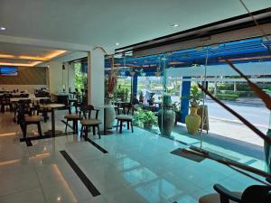 a restaurant with tables and chairs and a large window at Sam Homestay in Bangkok
