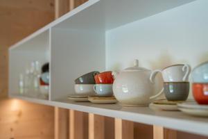 a shelf with bowls and tea pots on it at Apartment am Camping Dornbirn - 214 Staufen in Dornbirn +14 photos