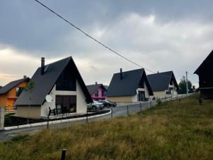 een rij huizen met zwarte daken op een heuvel bij Lux Villas Zabljak in Žabljak