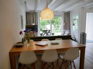 a living room with a wooden table and chairs at Jonas - Luxe appartement naast de duinen in Oosterend