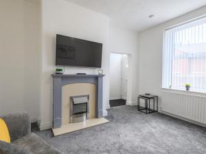 a living room with a fireplace with a tv above it at Spacious Oasis - Perfect for Large FamiliesGroups - Pass the Keys in Morley
