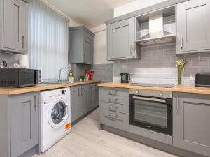 a kitchen with a washer and a washing machine at Spacious Oasis - Perfect for Large FamiliesGroups - Pass the Keys in Morley