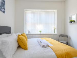 a bedroom with a bed with two towels on it at Spacious Oasis - Perfect for Large FamiliesGroups - Pass the Keys in Morley