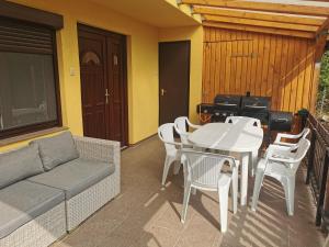 a patio with a couch and a table and chairs at Oxigén Apartman Igal in Igal