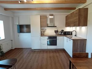 a kitchen with white appliances and wooden cabinets at Fewo Wiesenblick in Waldmünchen