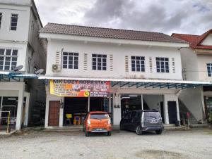 two cars parked in a parking lot in front of a building at Nick Cozy Homestay 1st Floor in Jeli