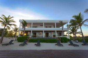 ein Gebäude am Strand mit Stühlen und Palmen in der Unterkunft Perfect Beach Location For Families And Weddings in Cancún