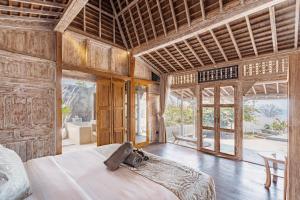 Un dormitorio con una cama en una habitación con paredes de madera. en Dolce Vita Nusa Penida, en Nusa Penida 53 fotos más