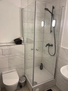 a bathroom with a shower with a toilet and a sink at Simple Stay Gladbach in Mönchengladbach +2 photos