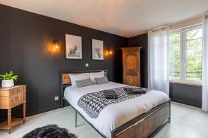 una camera da letto con un grande letto con pareti nere di La Couture - Campagne Normande - Proximité Pont-Audemer a Saint-Mards-de-Blacarville