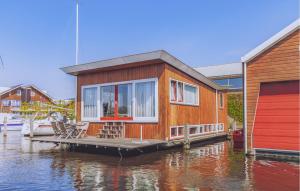 a house on a dock on a body of water at Woude in Uitgeest