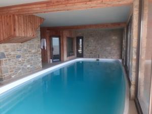 una grande piscina in una casa con un muro di mattoni di Chalet des Jonquilles - Magnifique maison avec piscine a Les Angles