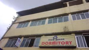 un edificio con un cartello sul lato di SUDHAKAR DORMITORYs a Panaji