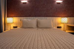 ein Schlafzimmer mit einem großen weißen Bett und zwei Lampen in der Unterkunft Hotel Dorna in Mamaia