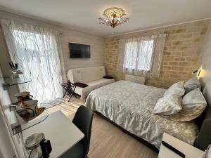 a bedroom with a bed and a chair and a table at Le mas des anges in Soussans +46 photos