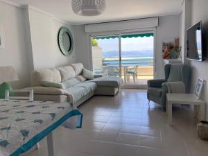 a living room with a couch and a view of the ocean at Vistamar in Santoña