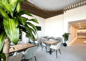 a restaurant with tables and chairs and a plant at HQ Arena Hotel in Valencia +42 photos
