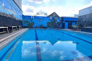a swimming pool with a mural on the side of a building at Hotel Kinasih Yogyakarta in Yogyakarta