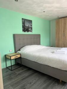 a bedroom with a large bed and a nightstand with a bed sidx sidx sidx at Chalet 4 persoons in Anloo