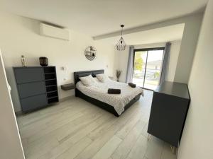 a bedroom with a bed and a large window at Villa Jérémy in Sanary-sur-Mer +28 photos