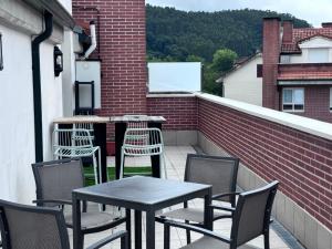 a patio with a table and chairs on a balcony at Ático a estrenar Ribamontán-Mar in Hoznayo