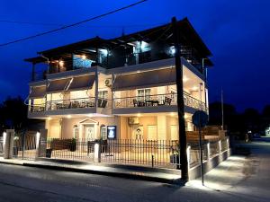 a large white building with a balcony at night at POSIDONIA RESORT No7 in Nea Vrasna