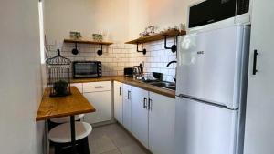 a kitchen with white cabinets and a white refrigerator at Vasco Diaz Beach in Mossel Bay