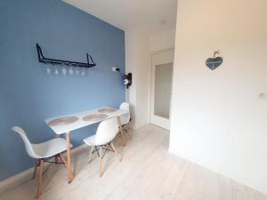 een eetkamer met een witte tafel en witte stoelen bij Lust auf Meer - Ferienwohnung in Cuxhaven