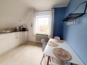 a kitchen with a table and chairs and a window at Lust auf Meer - Ferienwohnung für 4 Personen kleine Hunde willkommen Nähe Nordsee in Cuxhaven