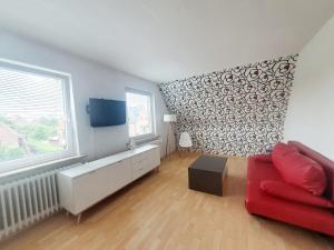 een woonkamer met een rode bank en een raam bij Lust auf Meer - Ferienwohnung in Cuxhaven