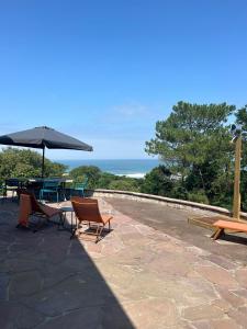 a patio with chairs and a table and an umbrella at Villa Denise in Bidart +17 photos