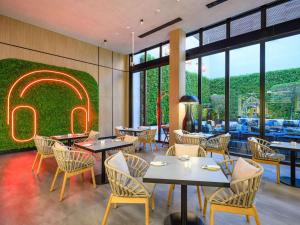 um restaurante com mesas e cadeiras e uma placa na parede em Ibis World Trade Centre no Dubai