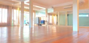 an empty room with a hard wood floor and curtains at Greenlight Fisherman's Village Resort & Café in Koh Samui 