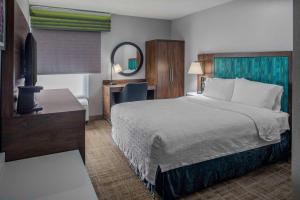 a hotel room with a large bed and a desk at Hampton Inn Detroit Northville in Northville +19 photos