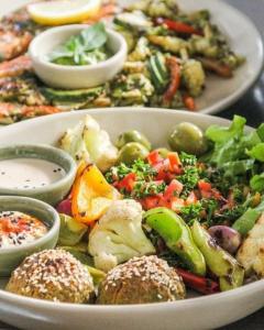 a white bowl of food with vegetables and other foods at Greenlight Fisherman's Village Resort & Café in Koh Samui 