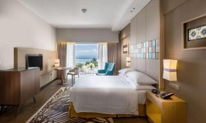 a hotel room with a bed and a view of the ocean at DoubleTree Resort by Hilton Hotel Penang in Batu Ferringhi