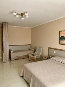 a bedroom with a bed and a chair and a couch at Anna House in San Marco dei Cavoti +4 photos