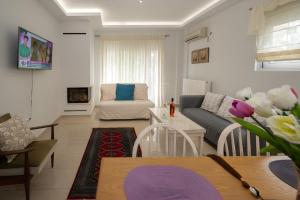 a living room with a couch and a table at Lux 1-bedroom condo-L&L Refuge in Athens