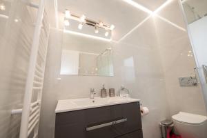 a bathroom with a sink and a toilet and a mirror at Lux 1-bedroom condo-L&L Refuge in Athens +11 photos